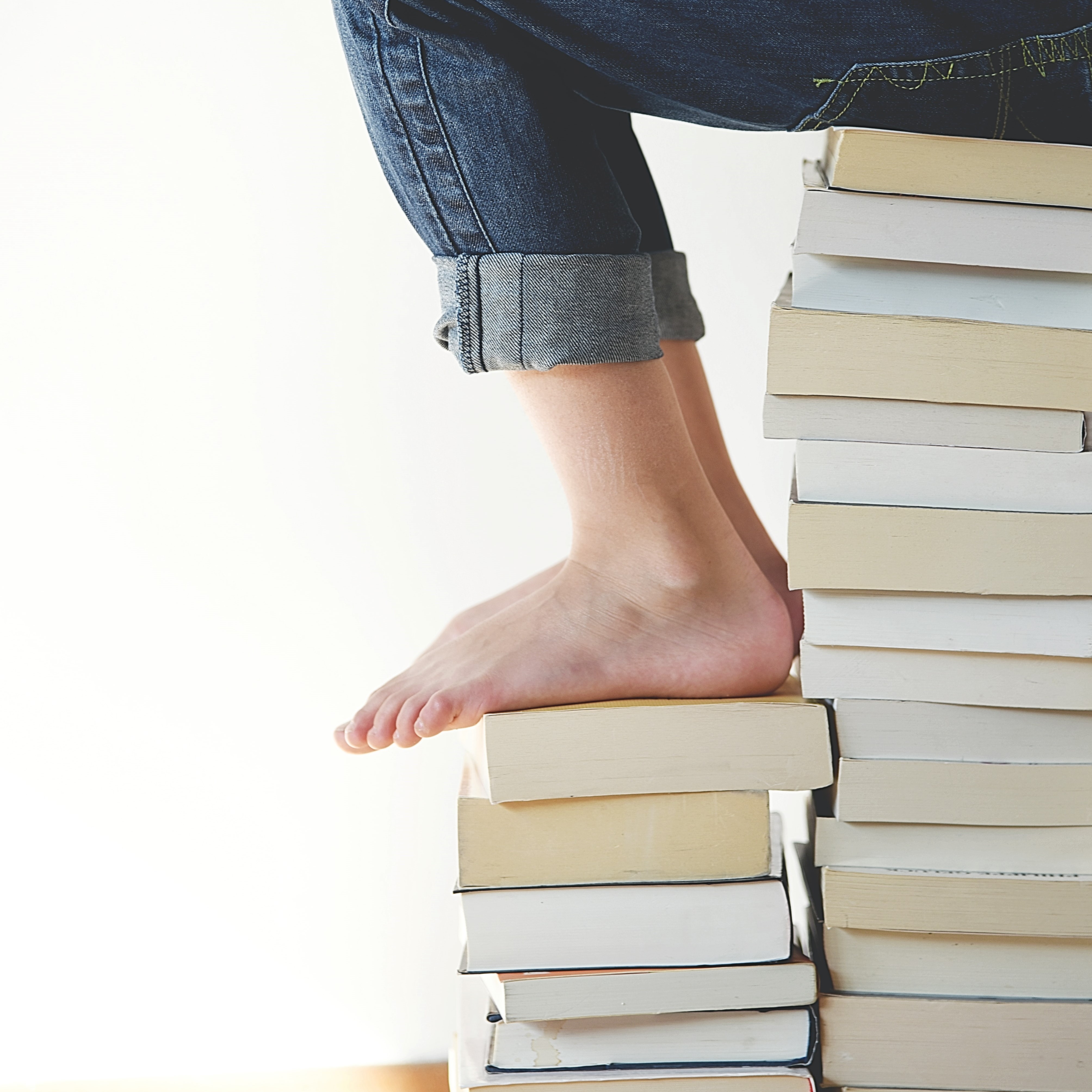 ein Kind das auf einem Bücherstapel sitzt